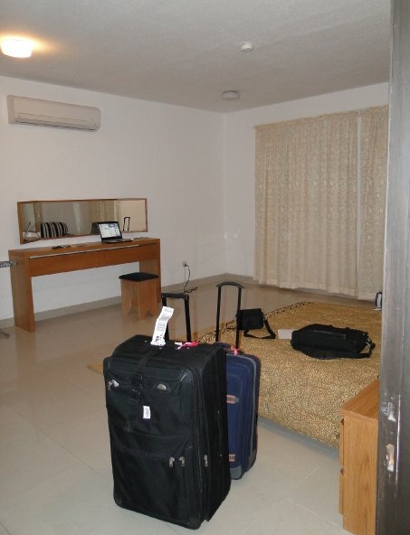 Suitcase open on the bed of a Riyadh serviced apartment, the disorienting first 90 days of relocating to Riyadh
