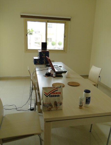 Laptop and takeout on a bare apartment table in Riyadh, the improvised first 90 days of moving to Riyadh